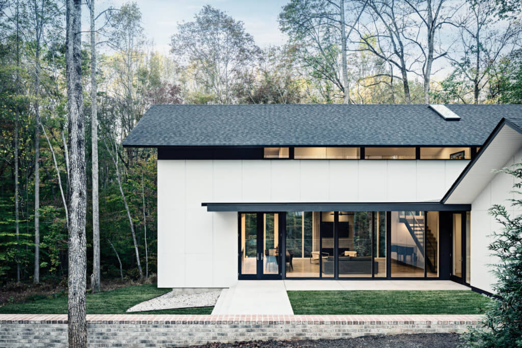 Modern house in the woods with many large windows in the front