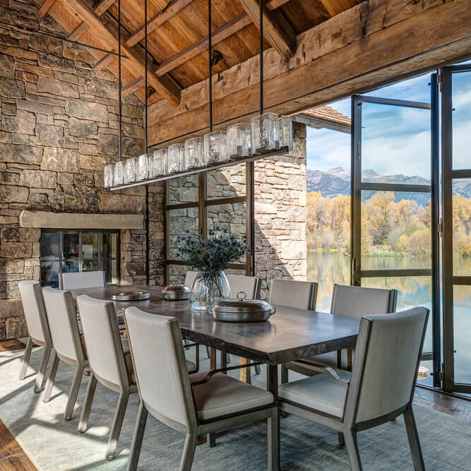 Beautiful long dining table enclosed by tall glass doors